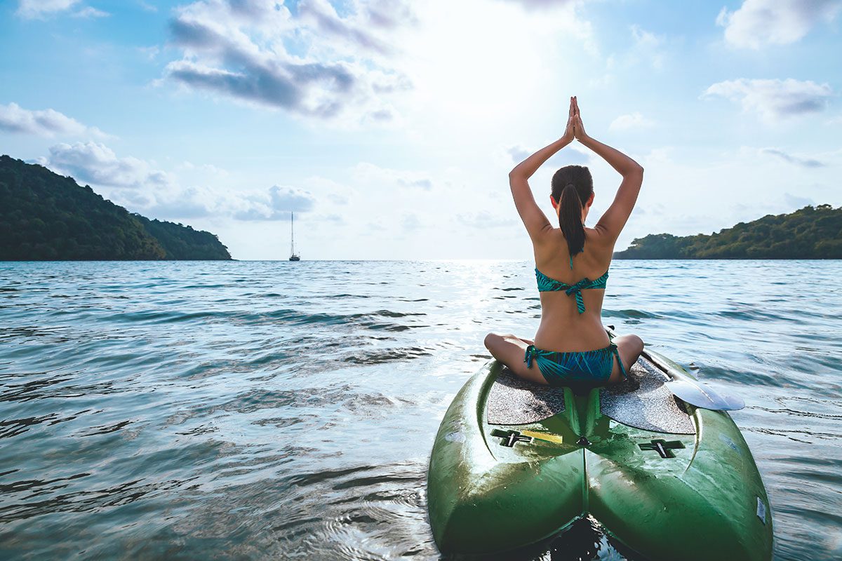 woman meditating on paddleboard