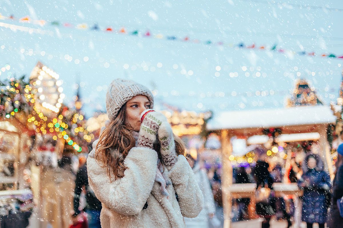 Woman drinking hot coffee on a Christmas market river cruise