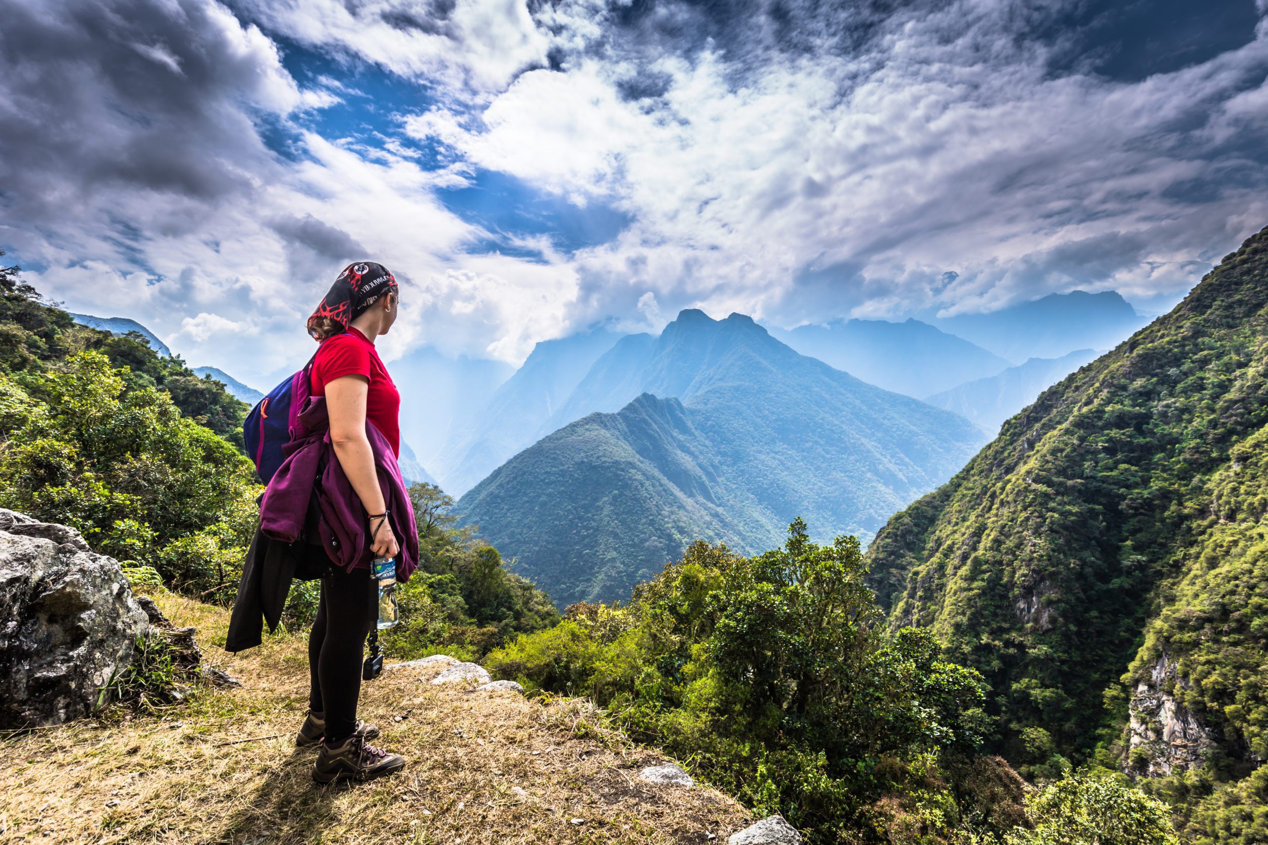 Woman overlooking Inca Trail with mountains in the distance after downsizing to travel