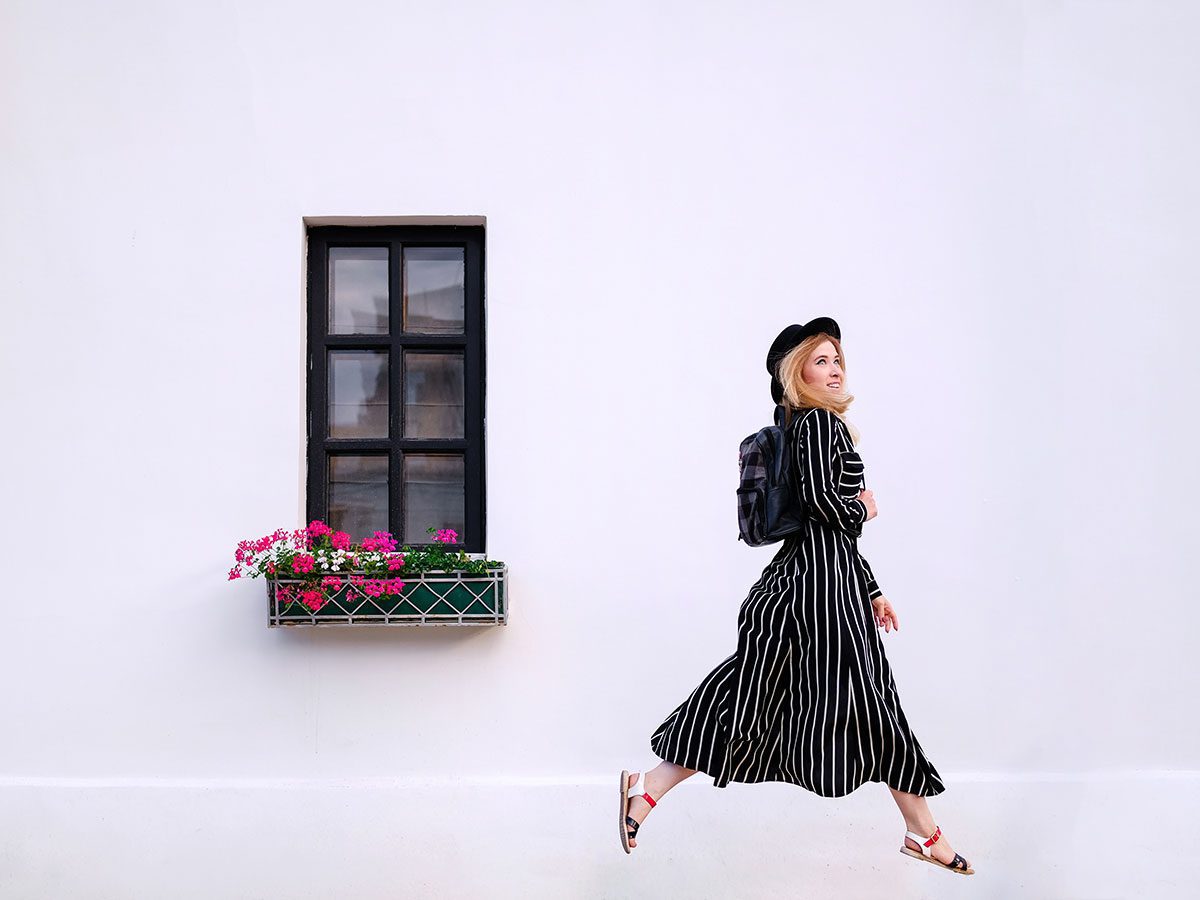 Happy young blonde woman with backpack