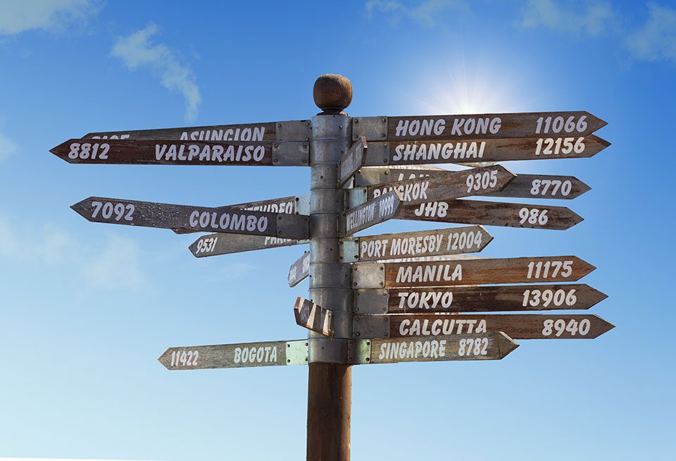 Guideposts pointing to different cities in the world