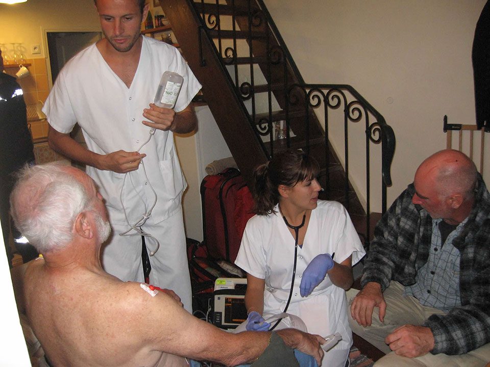 Older man being treated by two paramedics