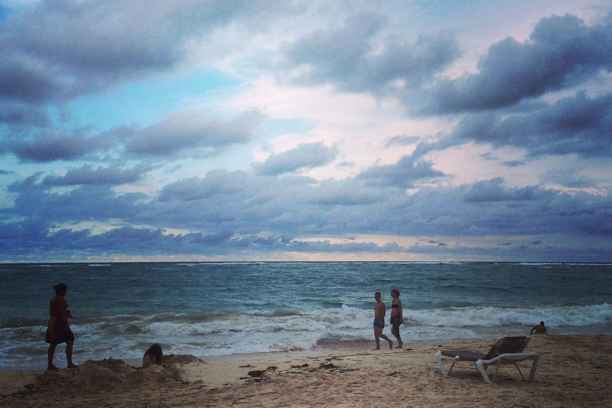 People walk the beach in the Dominican