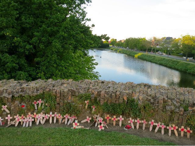 Crosses and poppies in front of a lake