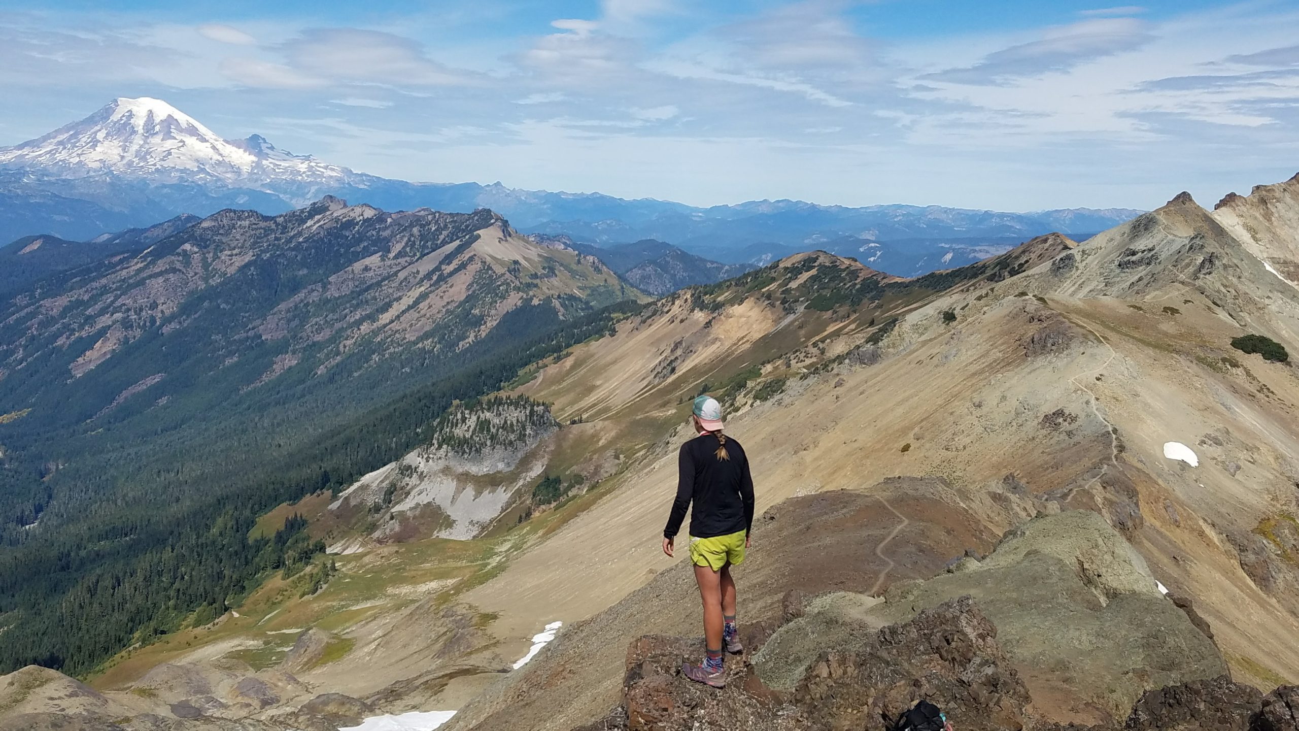 A solo woman hiker looking out over a mountain ridge