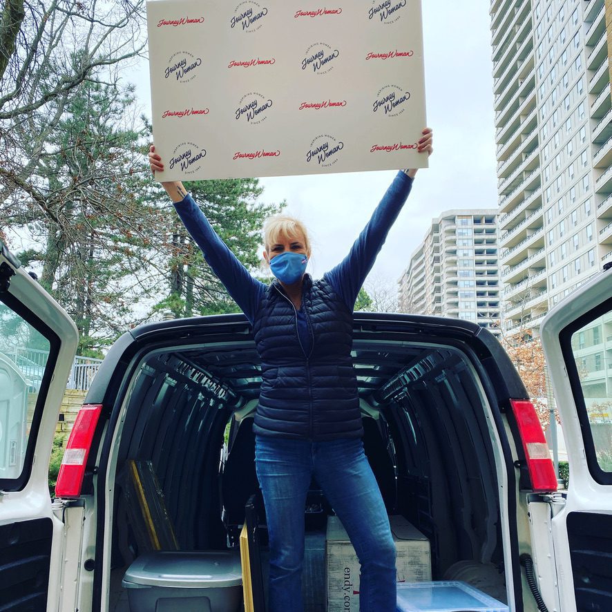 JourneyWoman editor Carolyn standing in the back of a cube van after downsizing for travel.