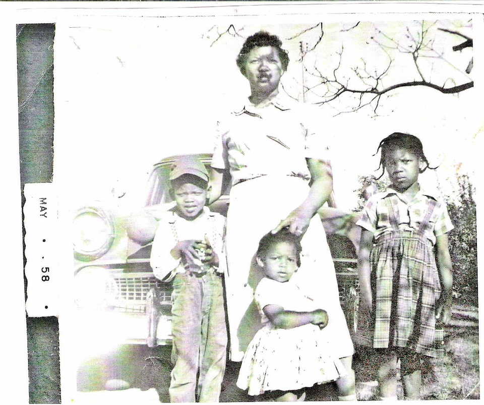 An old photograph with a women and three young children
