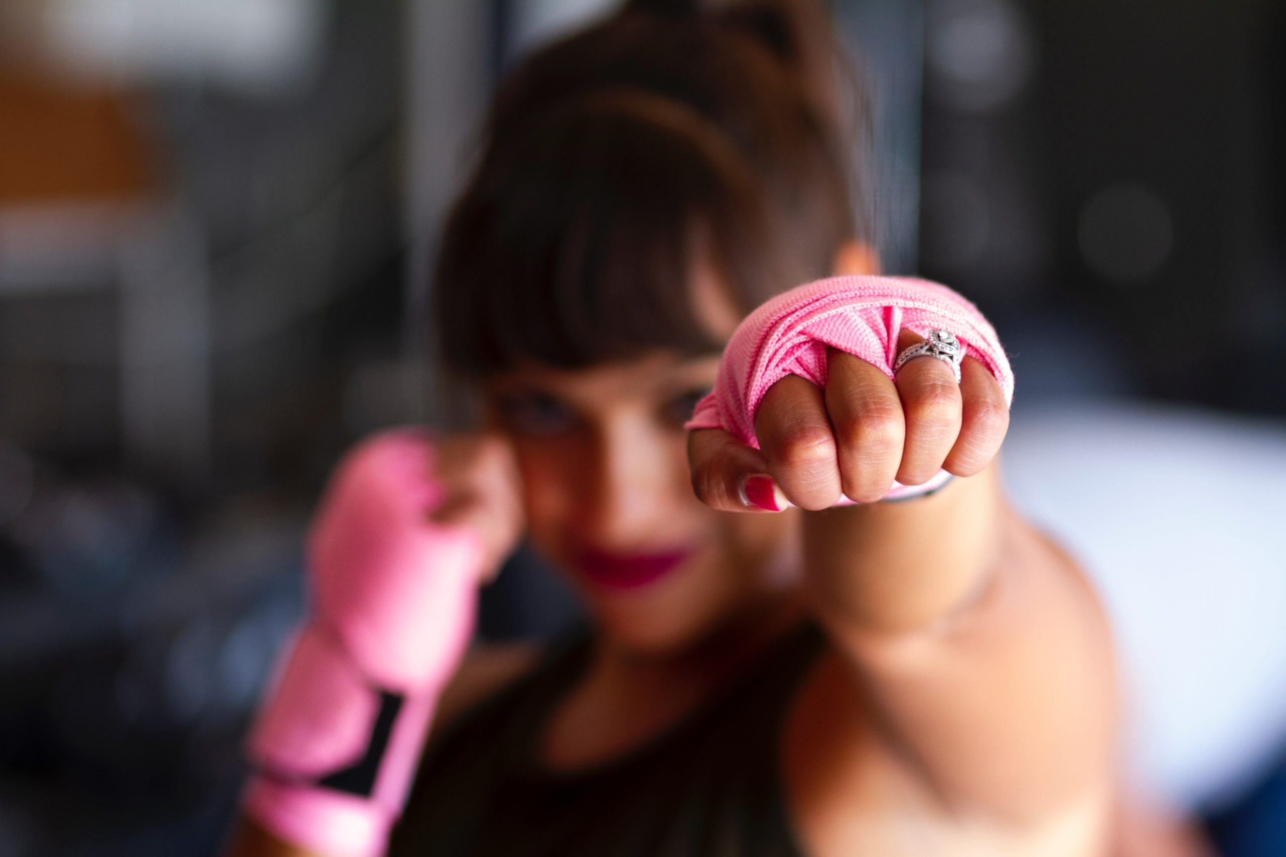 A woman holding up her fists, learning self-defense tips to stay safe.