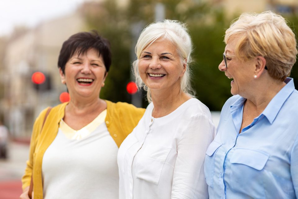 Three woman smiling together. Women's travel safety must go beyond tips.