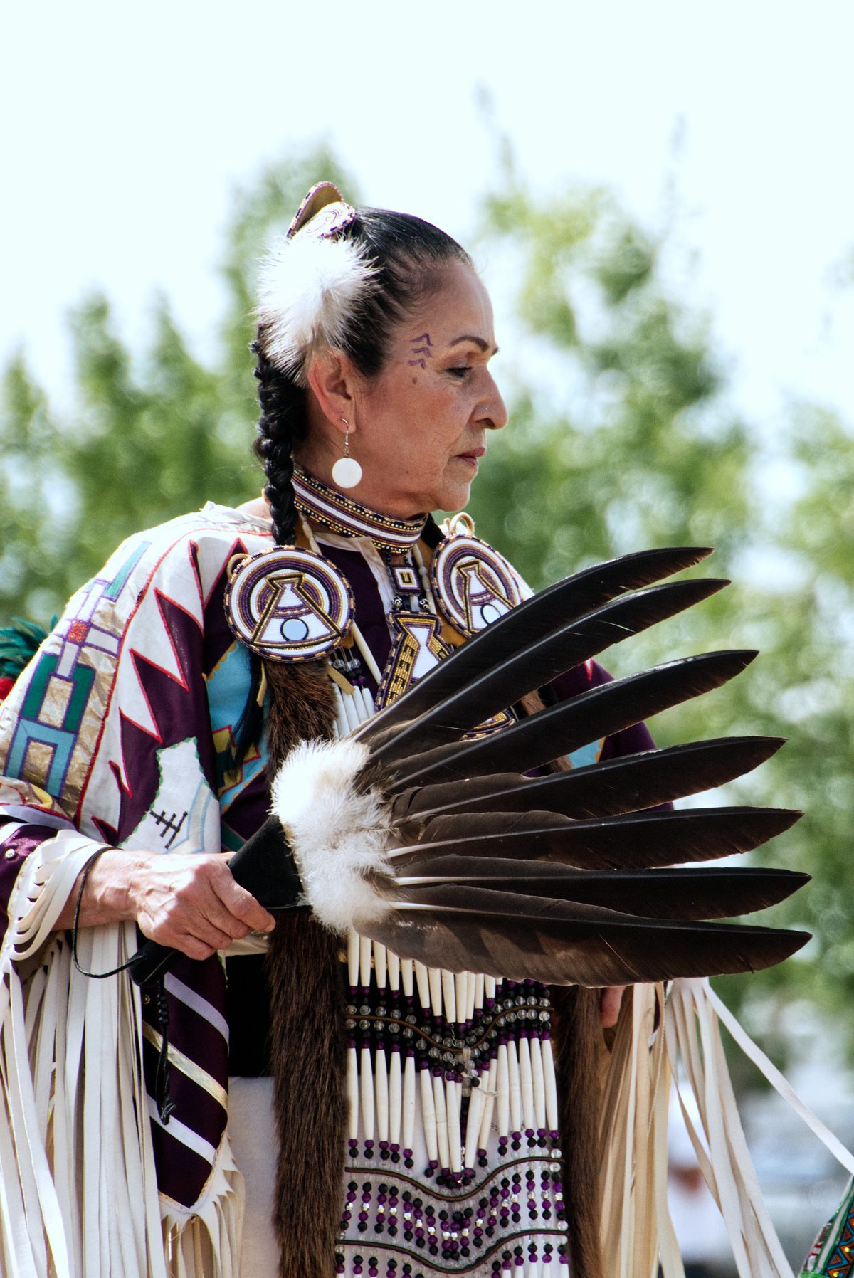 indigenous woman holding feathers
