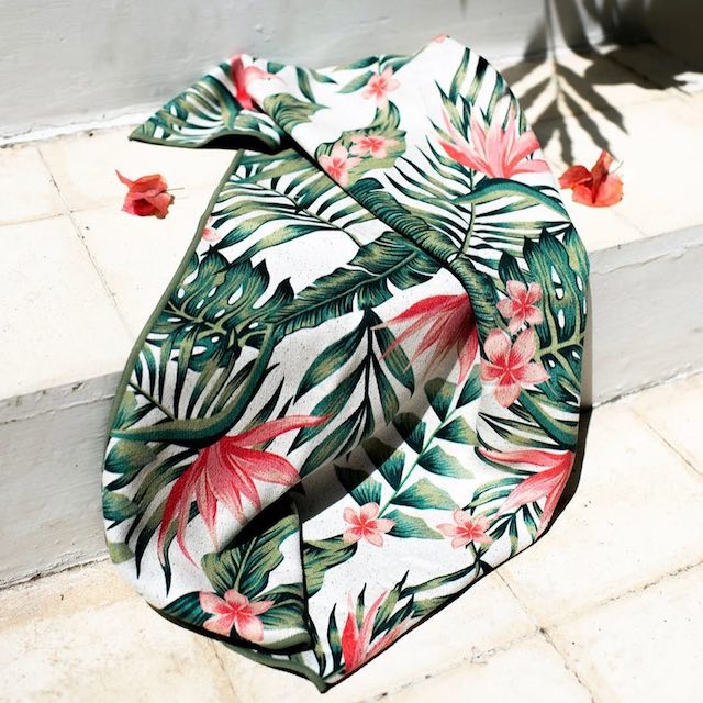 A Nomadix microfiber towel with a palm leaf print