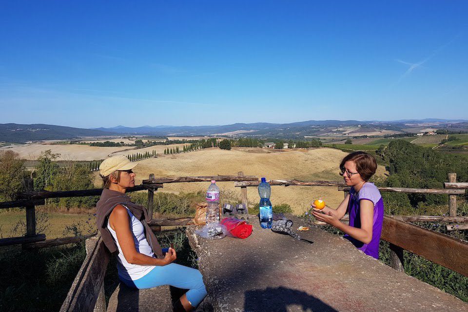 Two women enjoying a meal with a gorgeous view in Tuscany