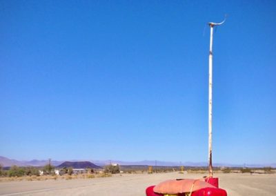A hotdog statue set against a bright blue sky