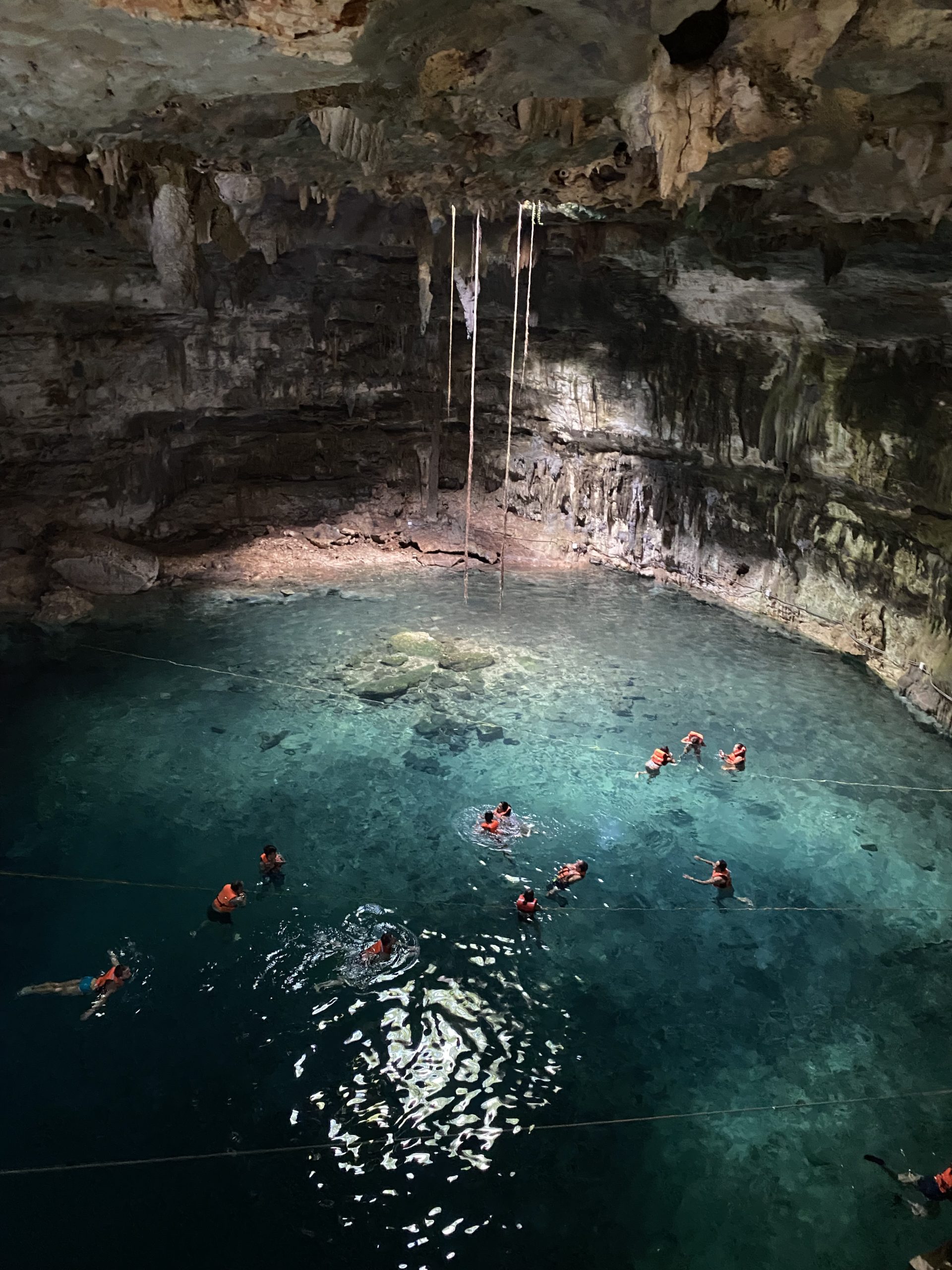 people swimming in a cenote when living in Mexico