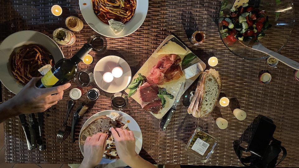 Overview of a homemade dinner in Rome, including fresh pasta and a bottle of wine.