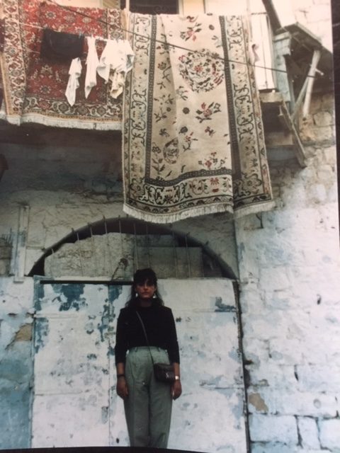 Anita Heriot Jessica woman standing in front of a house in safed