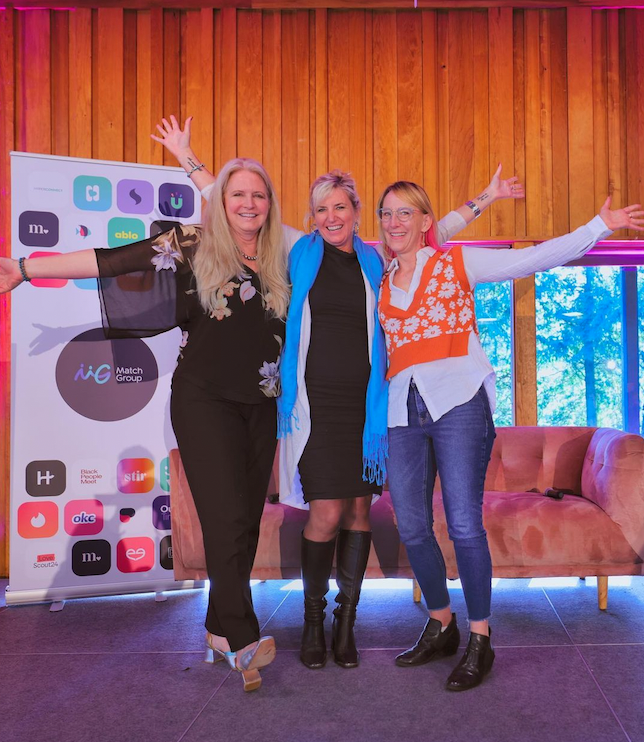 three women standing on stage