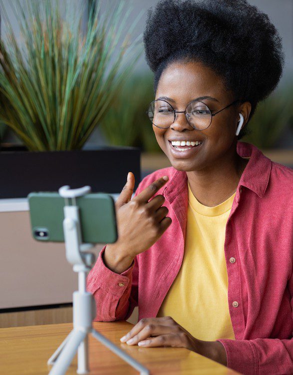 A woman is having a video call with her phone on a tripod