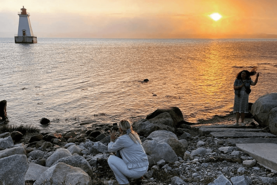 Women capture photos of the sunset in Sand Point Nova Scotia