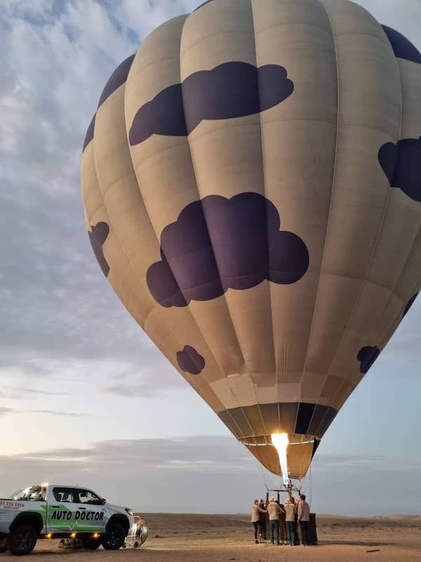 A hot balloon gets filled with hot air in the Namib desert