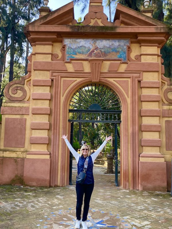 Carolyn Ray stands with her arms up in Seville, Spain