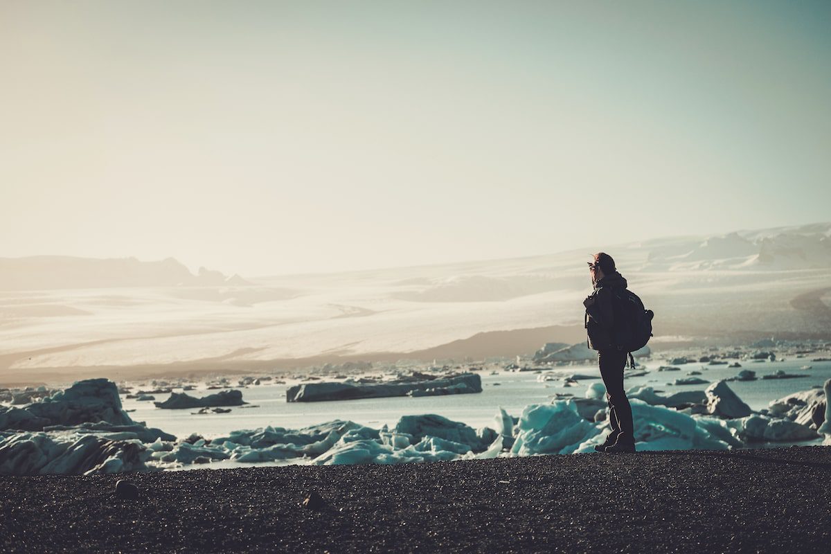 Woman explorer lookig at Jokulsarlon lagoon, Iceland