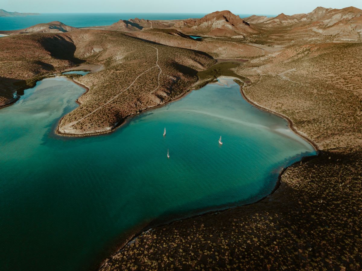 Blue ocean harbour against dried, brown hills in Bolivia