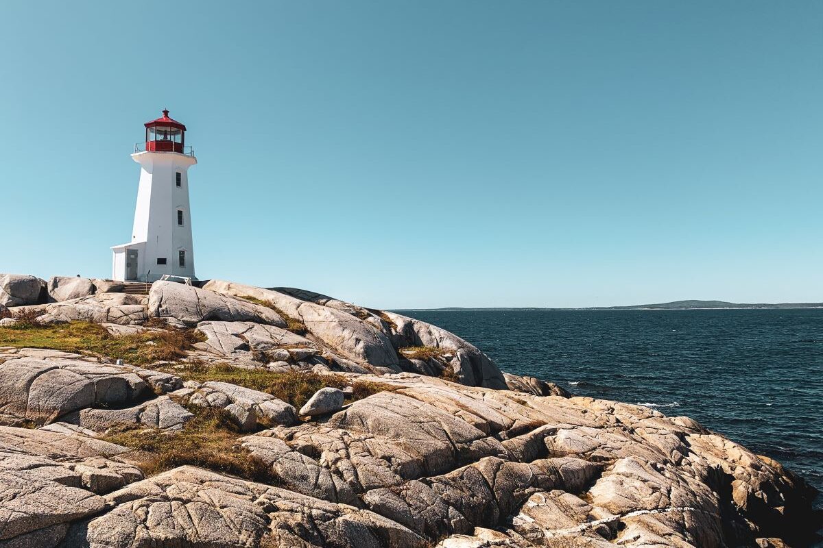 Lighthouse standing on top of rocks overlooking the ocean
