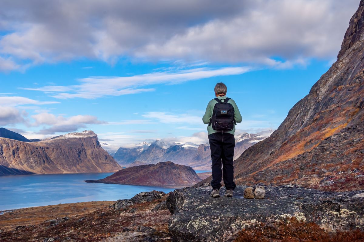 women standing overlooking the ocean harbour surrounded by mountains thinking about an Arctic departure with Wild Women Expedition