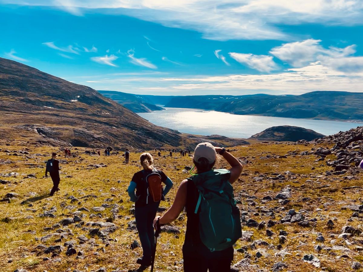 blue sky and ruggered terrain hill backdrop with women walking down