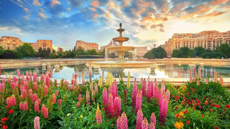 Pink tulips seen in front of an ornate fountain along a river cruise in Eastern Europe
