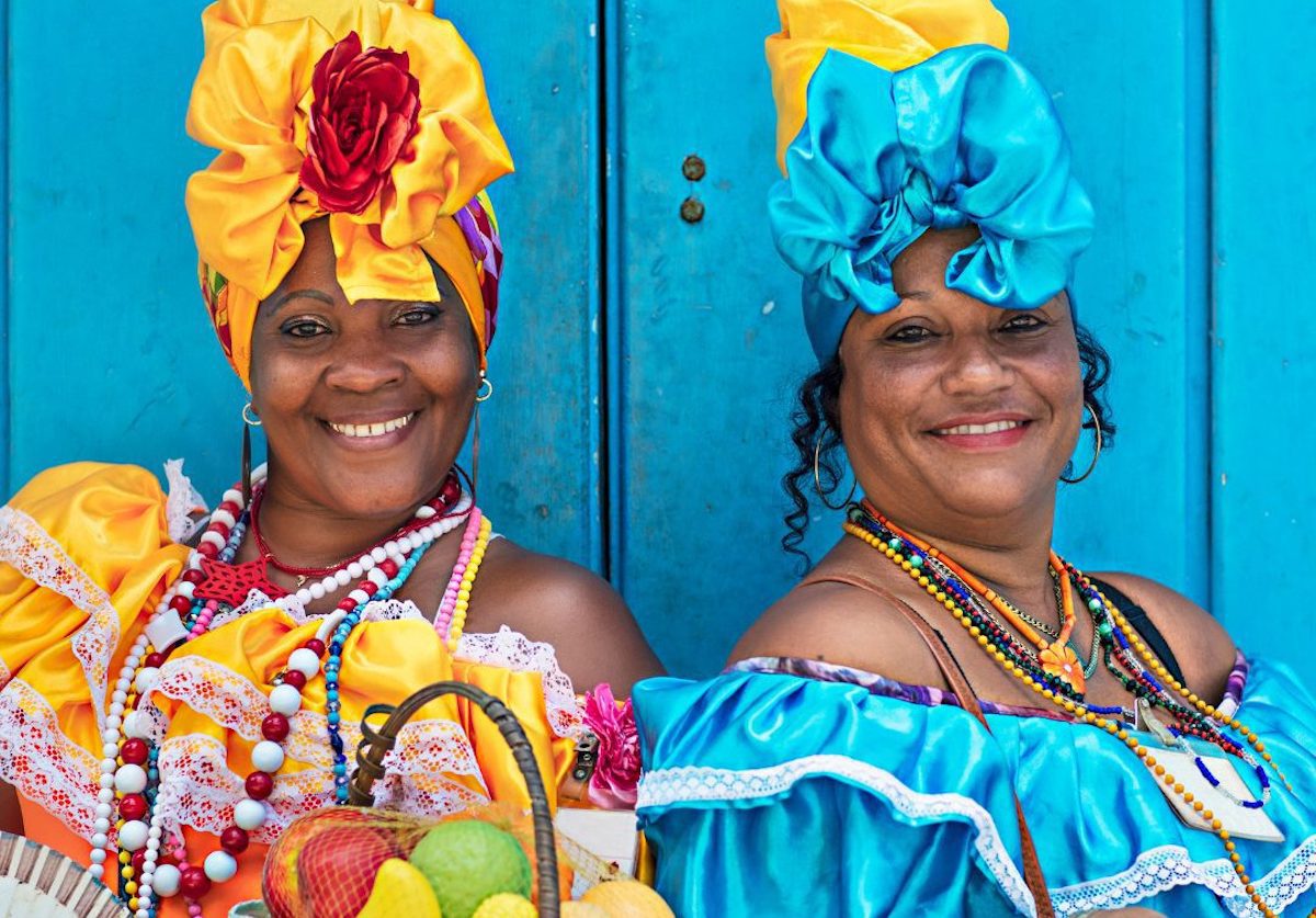 Two Cuban women wearing traditional bright coloured dresses