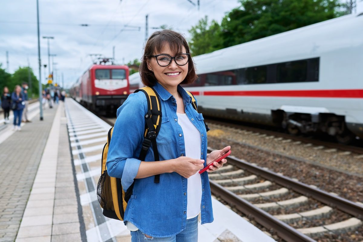 Woman passenger waiting for the train at station outdoor platform