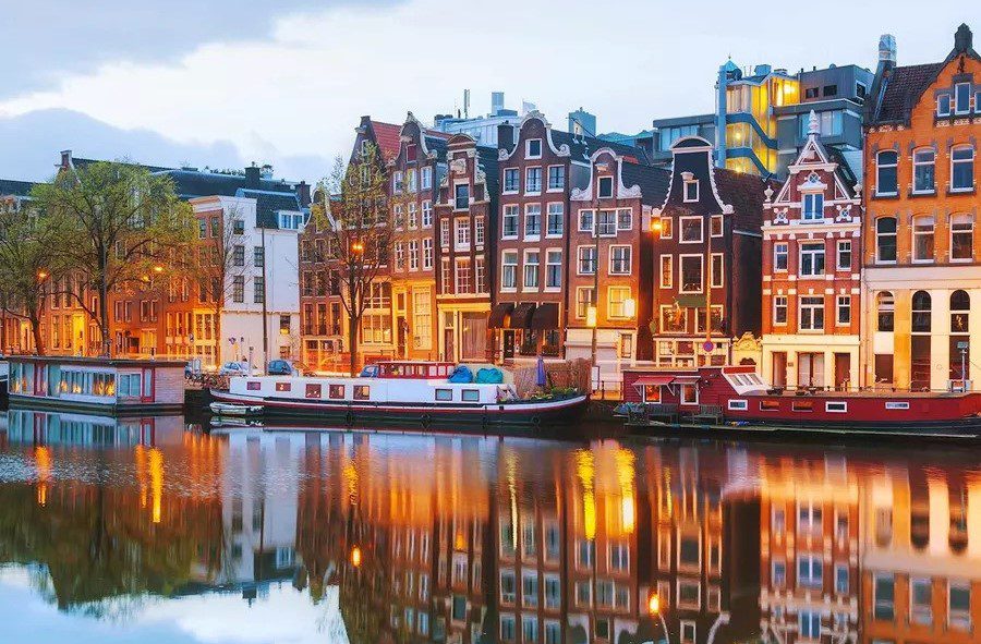 small scandi houses standing along the water in different colours