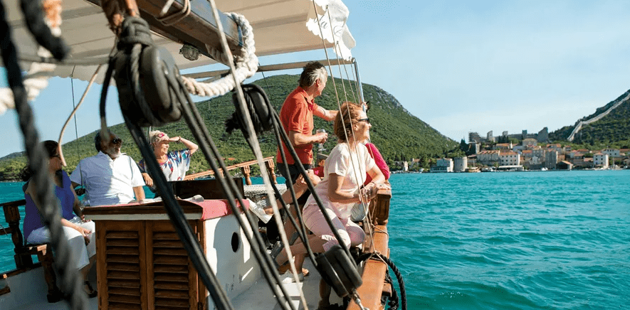 Woman standing on sailboat overlooking Croatia and the sea