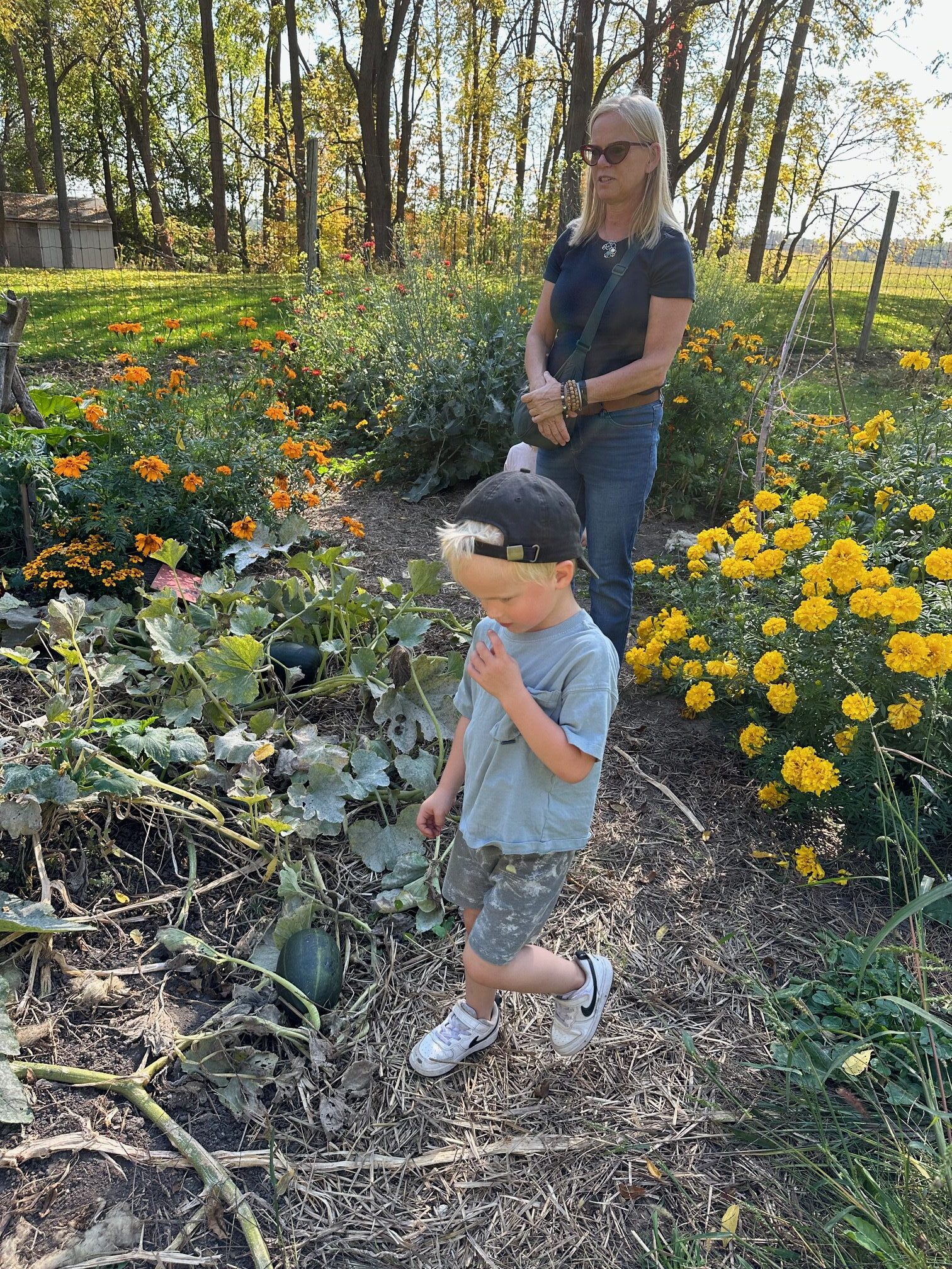 woman walking with grandchild in field for earth day