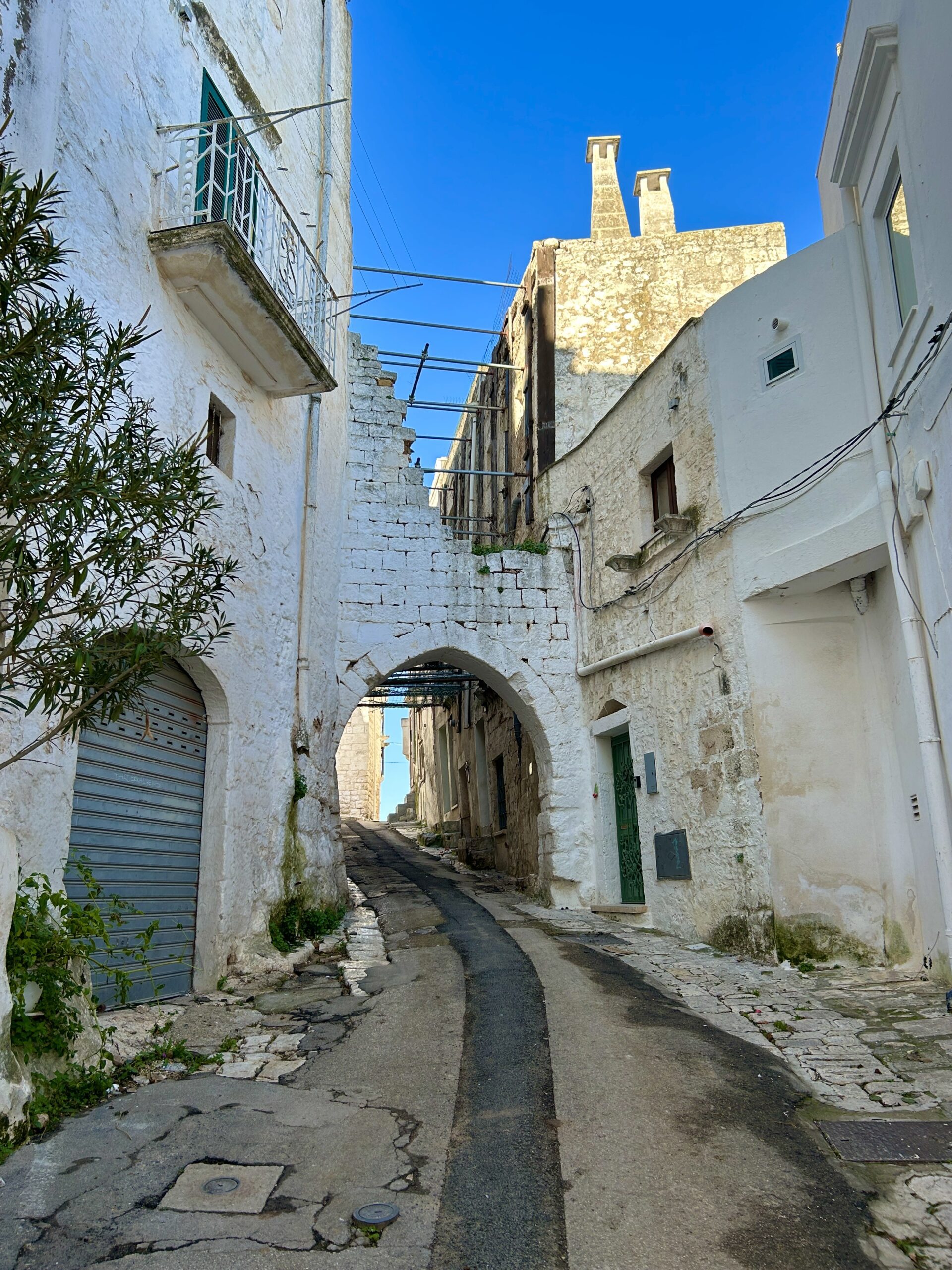 white arch over a cobblestone path in Ostuni the white village puglia italy