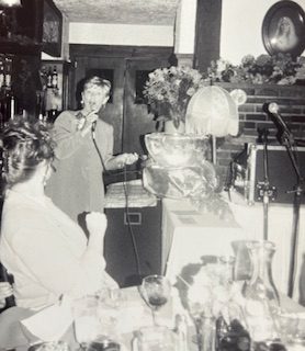 woman singing in a band with two others 