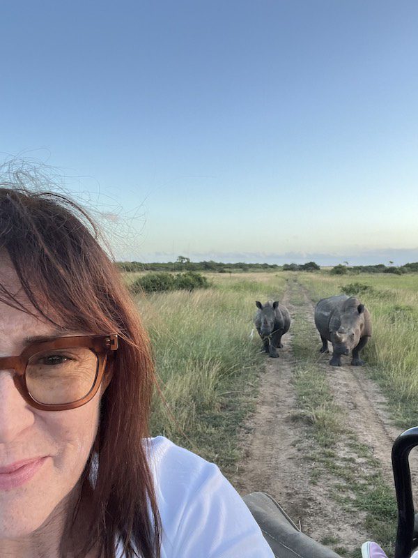 Kimberley Seldon on a safari in South Africa, with rhinos in the background