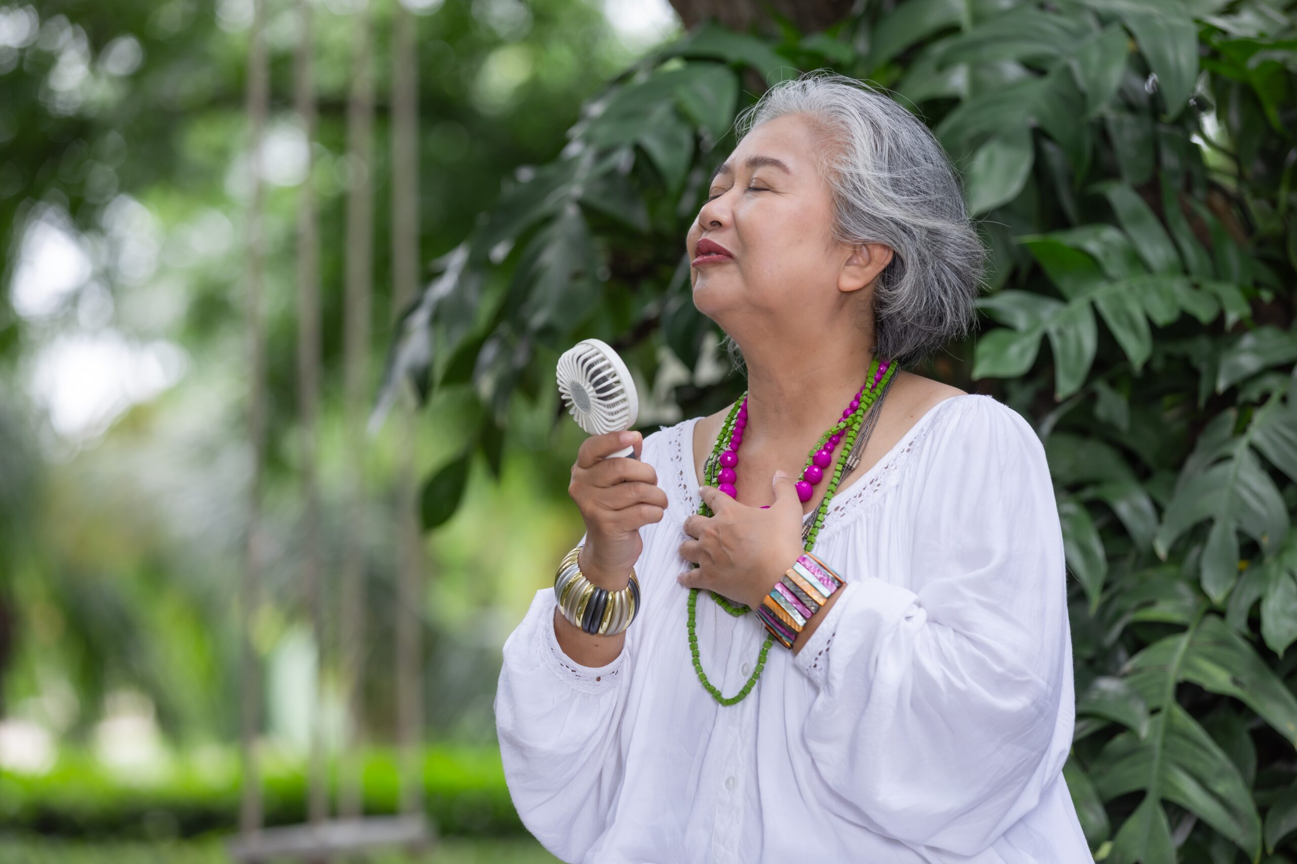 elderly-woman-with-grey-hair-feeling-joyful-outdoo-2024-07-22-21-12-35-utc (1) Elderly Woman with Grey Hair Feeling Joyful Outdoors, Holding a Hand Fan menopause