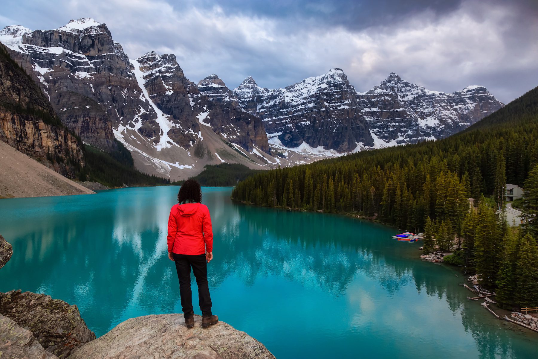 Woman looking at a beautiful Iconic Canadian Rocky Mountain Landscape during sunset. Taken at Moraine Lake, Banff National Park, Alberta, Canada.