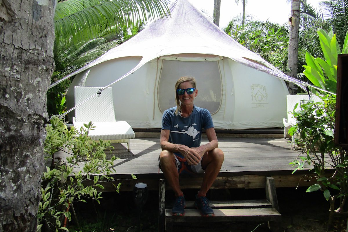Jules Torti sitting in front of a canvas tent, her perfect glamping headquarters at Nacpan Beach, Palawan Island