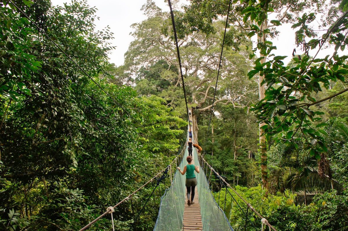 Women make their way across a suspension bridge in Peru jungle