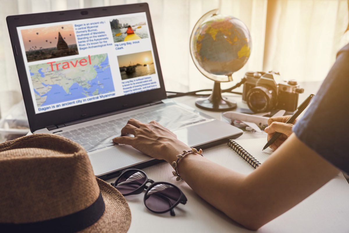 Woman planning a trip and searching for information on laptop, using AI in travel advice.