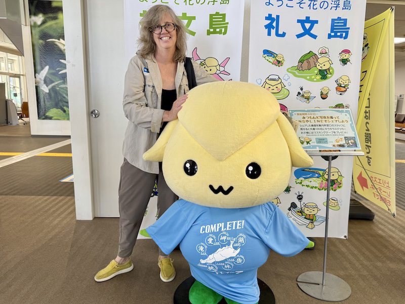 Author Jennifer Bain poses with the Atsumon mascot on Rebun Island