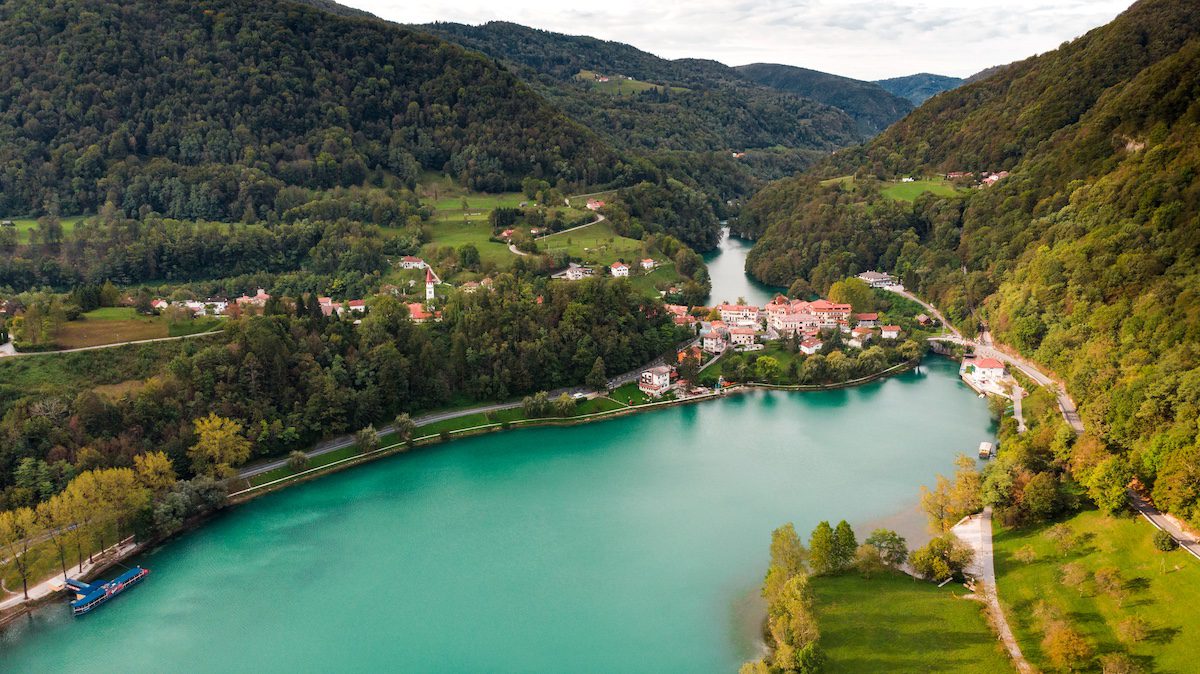 Most Na Soci Town at Emerald Lake Edge. Aerial View of Slovenia Countryside.