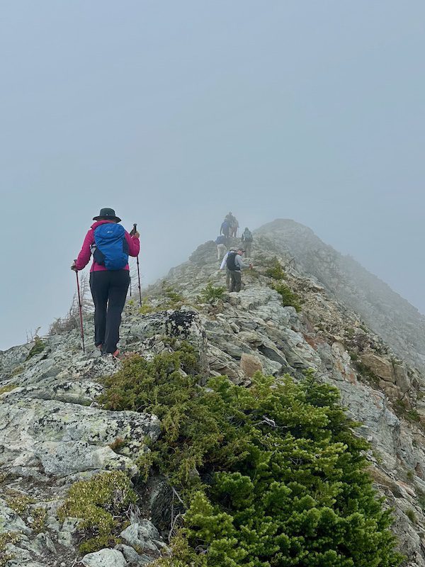 The writer ascends into the fog on a ridgeline hike in the Bugaboos